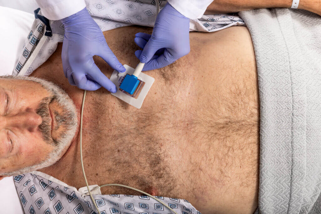 Physician placing iEcho24 probe on patients chest